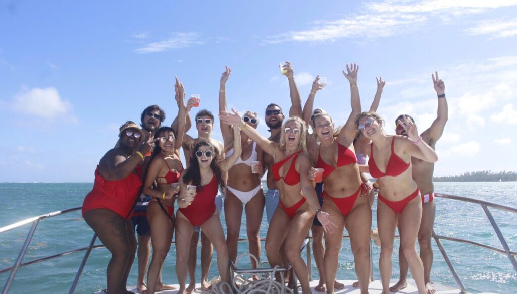 Group toasting in the Caribbean water beside the boat