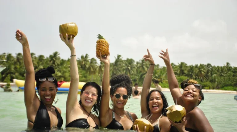 Friends toasting with coconuts and pineapple in the natural pool