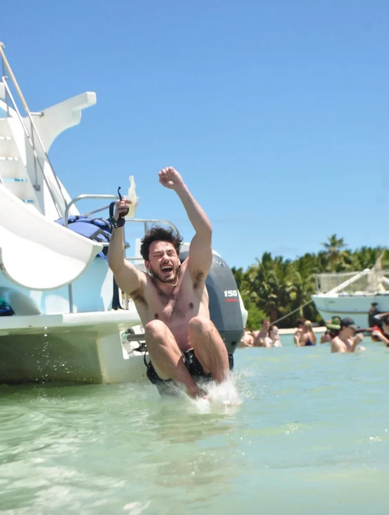 Guest celebrating in the water beside the catamaran slide in Punta Cana