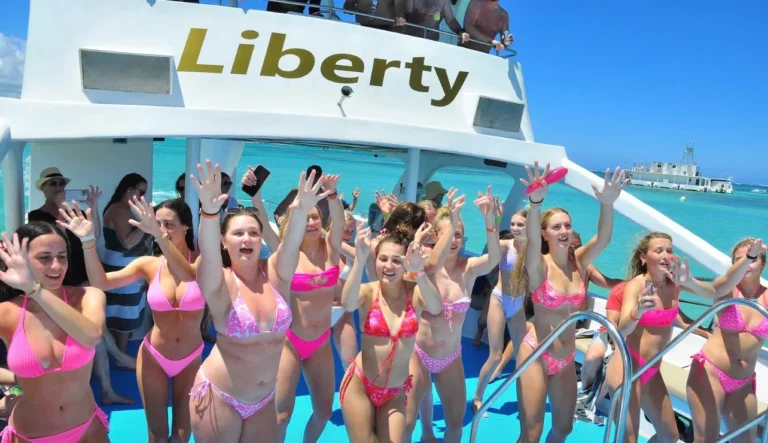 Group of friends posing beside the catamaran Liberty in Punta Cana