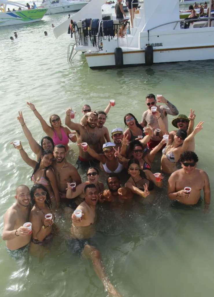 Group of guests celebrating in the water beside the boat in Punta Cana