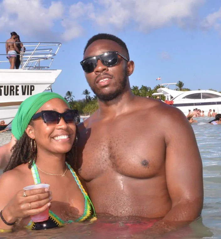 Couple enjoying their drinks in the water beside the boats in Punta Cana