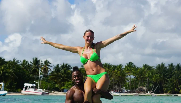 Guest with open arms over a companion shoulders in the water in Punta Cana