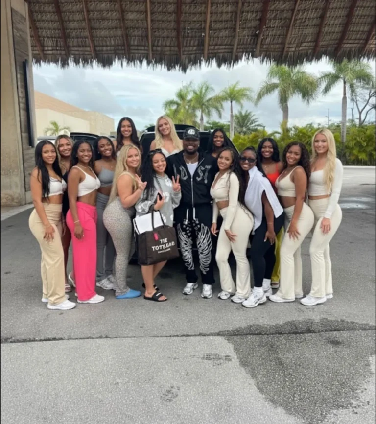 Yobi with a group of friends beside a black SUV under a palm-thatched roof in Punta Cana