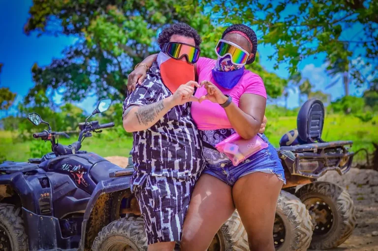 Two friends in helmets and bandanas beside an ATV in Punta Cana