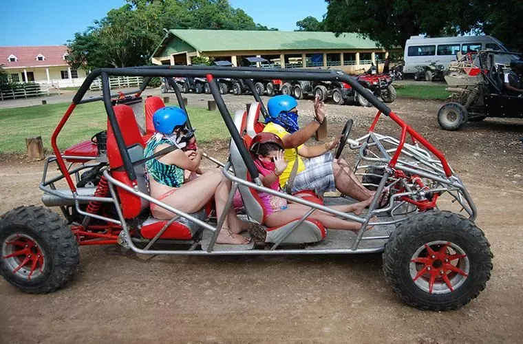 Family in helmets and bandanas aboard a four-seat buggy in Punta Cana