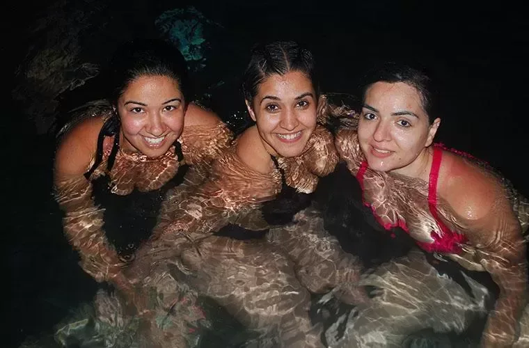 Three guests in the water inside a natural cave on the buggy route