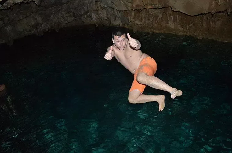 Guest jumping into the water inside a rock cave on the buggy route