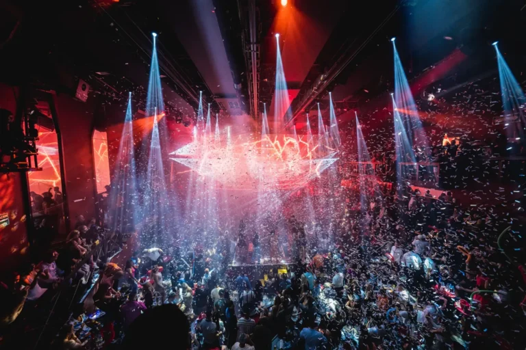 Packed Coco Bongo dance floor under stage lights during a rock tribute show