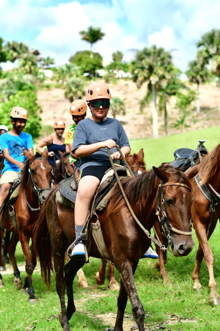 Guests riding horses between palm trees at La Hacienda Park