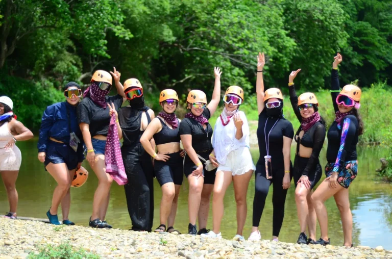 Guests in helmets and harnesses by the river at La Hacienda Park