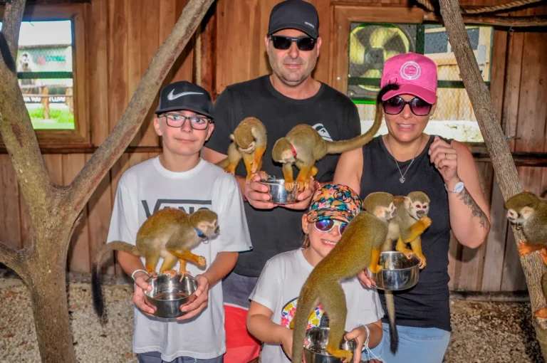 Family holding squirrel monkeys at the Monkey House in Punta Cana
