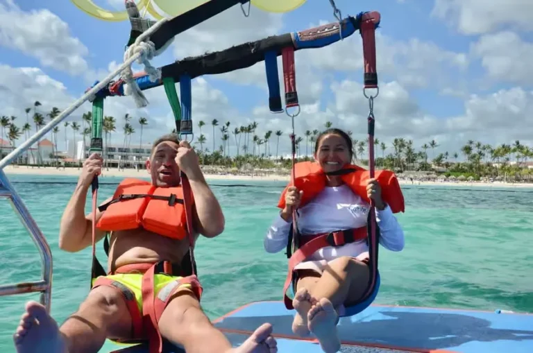 Couple in life jackets on the boat deck as the parasail lifts them off