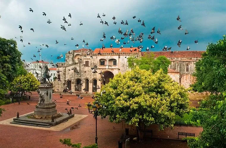 Pigeons over Parque Colon in front of the Cathedral of Santo Domingo