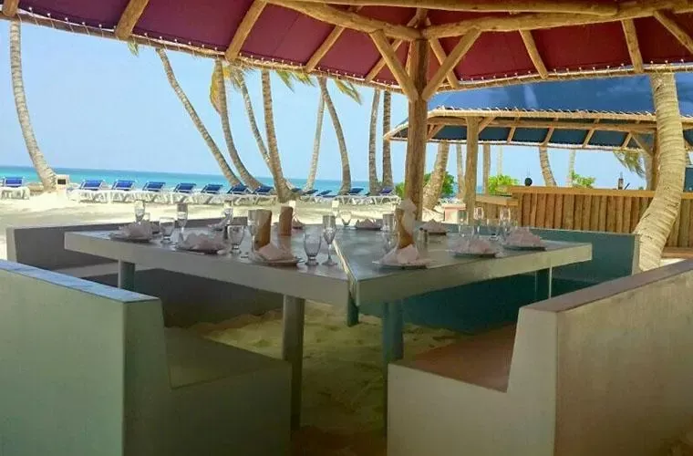 Tables set for lunch under a palapa beside the beach on Saona Island